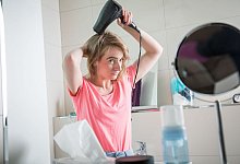 Eine junge Frau f&ouml;hnt ihre Haare - Christin Klose/dpa-tmn