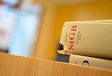 Eine Strafgesetzbuch liegt in einem Sitzungssaal - Nicolas Armer/dpa/Symbolbild