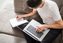 Ein Mann tr&auml;gt etwas in einen Kalender ein - Christin Klose/dpa-tmn