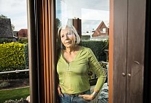 Eine Frau blickt aus einem Fenster auf einen Garten - Christin Klose/dpa-tmn