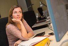 Frau schaut gelangweilt auf ihren Computerbildschirm - Klaus-Dietmar Gabbert/dpa-tmn