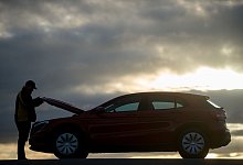 Mann öffnet die Motohaube eines Autos - Klaus-Dietmar Gabbert/dpa-tmn