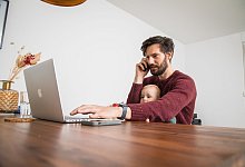 Mann mit Kleinkind vor Laptop - Christin Klose/dpa Themendienst/dpa-tmn