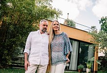 Paar steht vor einem Einfamilienhaus - Zacharie Scheurer/dpa-tmn