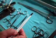 Der Chirurg hält im OP ein Skalpell in der Hand. (Archivbild) - picture alliance / dpa