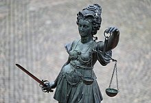Eine Bronzefigur der Justitia mit Schwert und Waage - Arne Dedert/dpa/Symbolbild