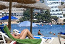 Vor der Kulisse zahlreicher Hotels entspannen Touristen am Strand - Clara Margais/dpa/dpa-tmn