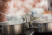 Dampfende T&ouml;pfe auf einem Herd - Jens B&uuml;ttner/dpa/dpa-tmn