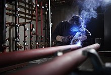 Anlagenmonteur, Monteur mit Schwei&szlig;maske bei Schwei&szlig;arbeiten an Rohren, &Ouml;sterreich, Europa - picture alliance / imageBROKER | Christian Vorhofer