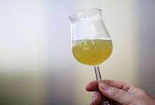 Eine Frau hält ein Glas mit Traubensaft in der Hand - Fredrik von Erichsen/dpa/dpa-tmn