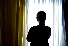 Frau steht vor Fenster - Foto: Peter Steffen/dpa