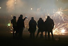 Gruppe von Menschen entzündet Feuerwerksraketen - Thomas Frey/dpa/dpa-tmn