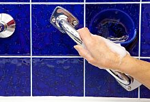 Eine Hand greift einen Haltegriff im Bad - Kai Remmers/dpa-tmn