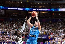 Dennis Schröder (l) versucht gegen Sloweniens Luka Doncic zu verteidigen. - Federico Gambarini/dpa