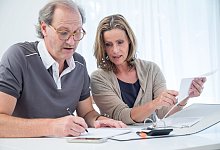 Ein Mann und eine Frau arbeiten an Unterlagen auf dem Tisch. - Christin Klose/dpa-tmn