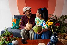 Freunde sitzen mit einer Kokosnuss auf einem Sofa - Pau Cardellach Lliso/Westend61/dpa-tmn