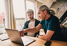 Zwei Personen an einem Laptop - Zacharie Scheurer/dpa-tmn