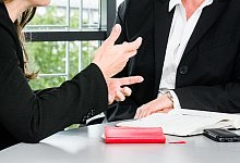 Zwei Kolleginnen diskutieren miteinander - Markus Scholz/dpa-tmn