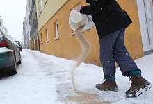 Eine Person streut Sand - Bodo Marks/dpa/dpa-tmn