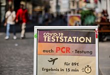 Ein Schild weist auf eine Teststation in der Innenstadt von Halle hin. - Jan Woitas/dpa