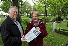 Flei&szlig;ig in der Nachbarschaft gesammelt: Heinz und Christel B&auml;z mit Unterschriftenliste und Stelenbild im oberen Bereich des Friedhofs in Spork-Eichholz. Auf der Fl&auml;che im Hintergrund k&ouml;nnten sie sich Urnenstelen gut vorstellen. - Bernhard Preu&szlig;
