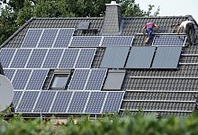 Monteure installieren eine PV-Anlage auf einem Hausdach - Rainer Jensen/dpa/dpa-tmn