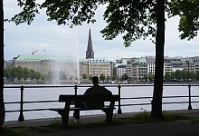 Ein Mann sitzt auf einer Parkbank - Marcus Brandt/dpa/dpa-tmn