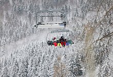 Skifahrer sitzen in einem Sessellift - Thomas Banneyer/dpa/dpa-tmn