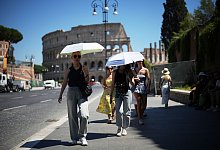 Menschen in Rom schützen sich mit Schirmen vor der Hitze - Andrew Medichini/AP/dpa-tmn