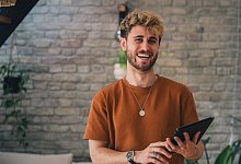 Ein Mann mit Tablet im Homeoffice - Zacharie Scheurer/dpa-tmn