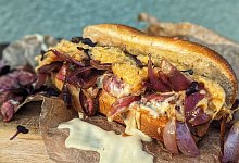 Ein Philly Cheesesteak auf einem Holzbrett - Doreen Hassek/dpa-tmn