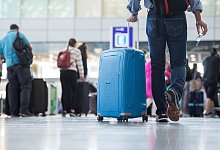 Ein Passagier geht mit einem Koffer Flughafen - Silas Stein/dpa/dpa-tmn