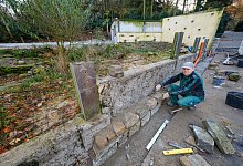 Tierpark-Mitarbeiter Abram Regier verkleidet die &auml;u&szlig;ere Mauer der neuen Anlage mit Natursteinen. - Foto: Andreas Zobe/NW