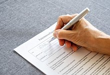 Eine Person füllt eine Patientenverfügung aus - Benjamin Nolte/dpa-tmn