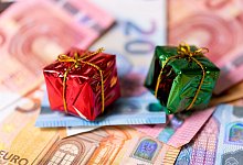 Miniaturweihnachstgeschenke kiegen auf Geldscheinen - Monika Skolimowska/dpa/dpa-tmn