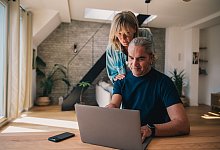 Paar schaut gemeinsam auf einen Laptop - Zacharie Scheurer/dpa-tmn