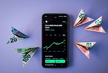 Geldscheinflieger zeigen auf einen ETF Kursverlauf - Christin Klose/dpa-tmn