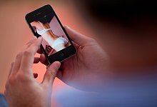 Frau in Unterw&auml;sche auf Handy - Foto: Julian Stratenschulte/dpa