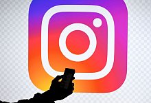Ein Smartphone vor dem Logo von Instagram. - Carsten Rehder/dpa