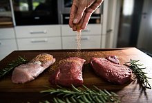 Eine Perosn w&uuml;rzt Fleisch - Andreas Arnold/dpa/dpa-tmn