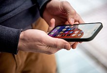 Mann hält ein Smartphone in der Hand - Zacharie Scheurer/dpa-tmn