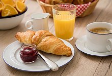 Ein Croissant ist auf einem Frühstückstisch zu sehen - Christin Klose/dpa-tmn