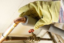 Ein Mann isoliert in einem Keller ein Heizungsrohr - Kai Remmers/dpa-tmn