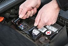 Mann wechselt eine Autobatterie - Bodo Marks/dpa-tmn