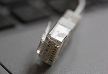 Ein LAN-Kabel liegt auf einem Computerlaptop: Rechtsanspruch auf Versorgung mit Telefon und schnellem Internetzugang. - Fernando Gutierrez-Juarez/dpa-Zentralbild/dpa