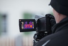 Ein Mann macht Wärmebildaufnahmen eines Wohnhauses - Tobias Hase/dpa-tmn