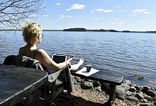 Mit dem Laptop am See - Jussi Nukari/Lehtikuva/dpa