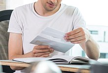 Ein Mann öffnet einen Brief - Christin Klose/dpa-tmn