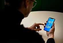 Ein Mann öffnet eine App auf seinem Smartphone - Zacharie Scheurer/dpa-tmn