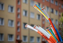 Glasfaser-Kabel ragen aus einem Schaltschrank heraus - Jan Woitas/dpa